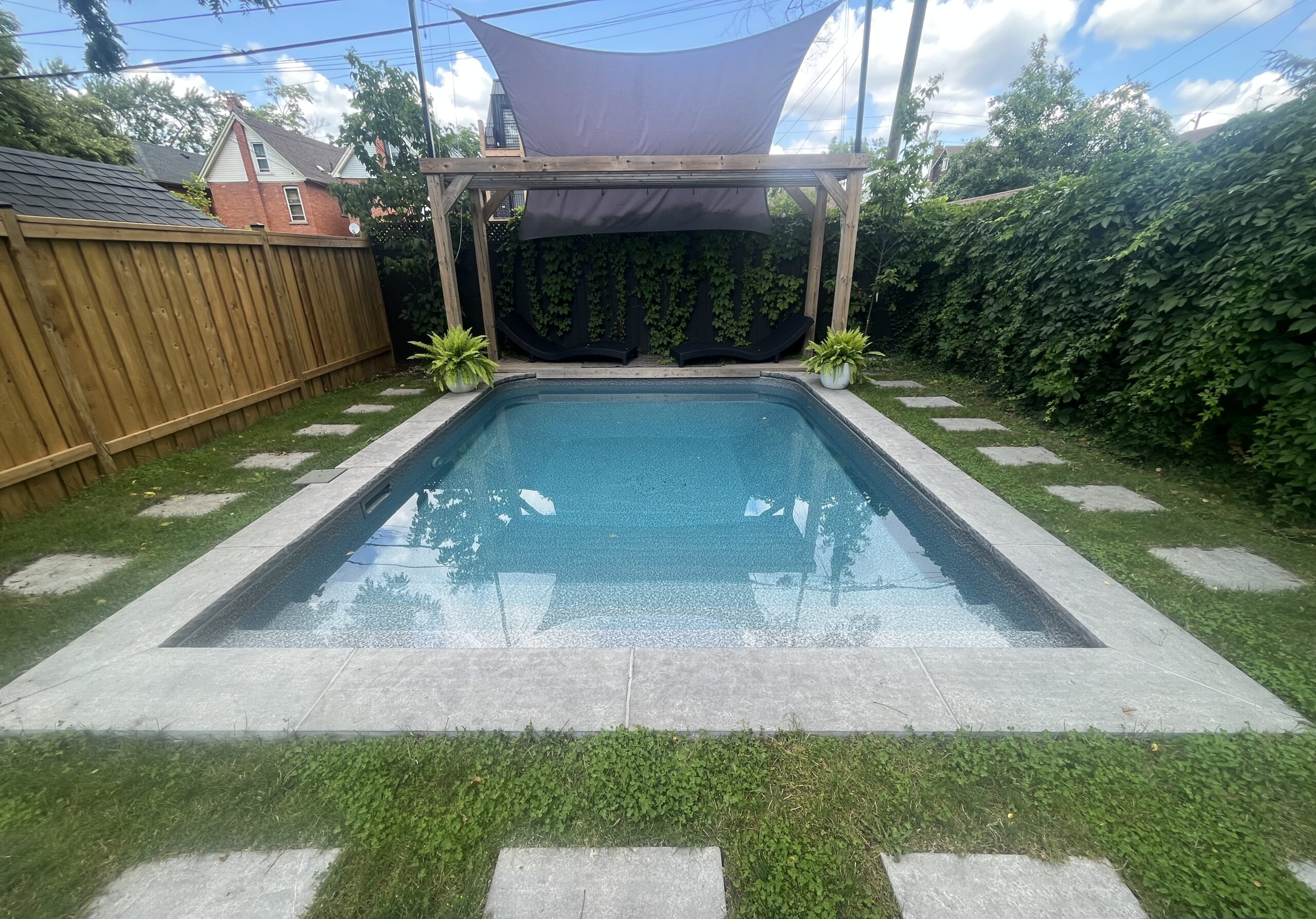 Modern rectangular swimming pool with clean lines and sleek coping installed in a Hamilton backyard.