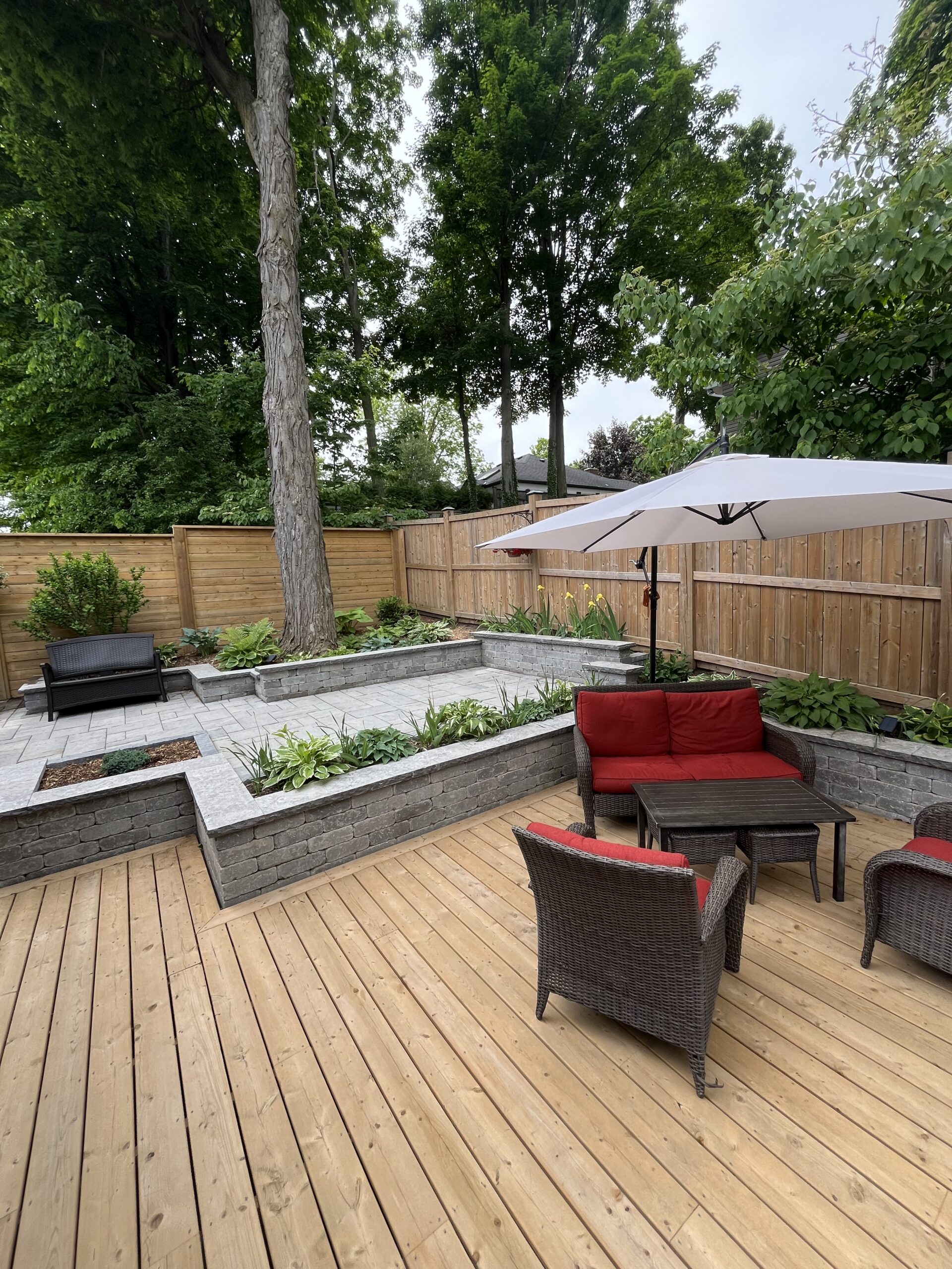 Custom wood deck designed by Level Above to blend naturally with the trees and landscape of a Whitby backyard