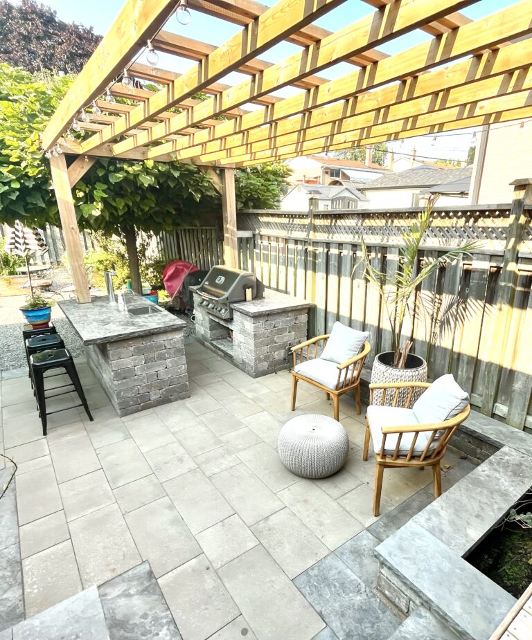 Fully equipped outdoor kitchen built with stone veneer and featuring a built-in grill