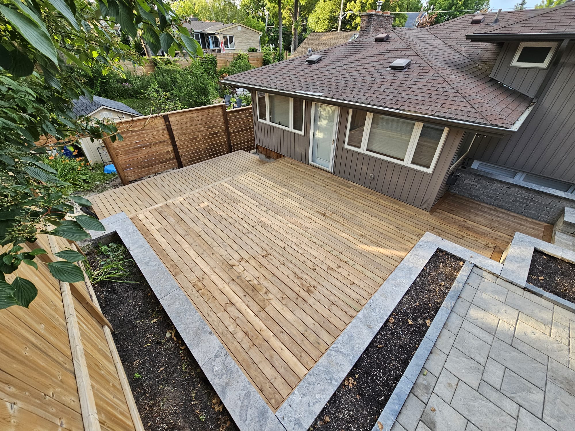 Custom wood deck construction by Level Above in Ajax, ON, creating a spacious backyard outdoor living space.
